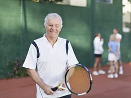 older man holding tennis racket gettyimages .jpg