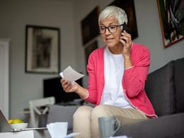 senior holding check and talking on phone.jpg