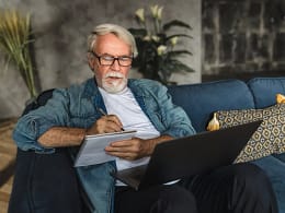 senior holding laptop and writing note in notebook.jpg