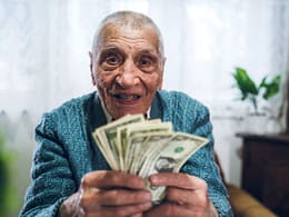senior man counting cash money bills social security retire invest inflation cola getty.jpg