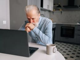 senior man laptop kitchen serious gettyimages .jpg