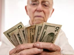 senior holding assortment cash bills social security retire getty.jpg