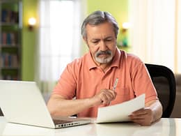 mature person holding pen and looking at document.jpg