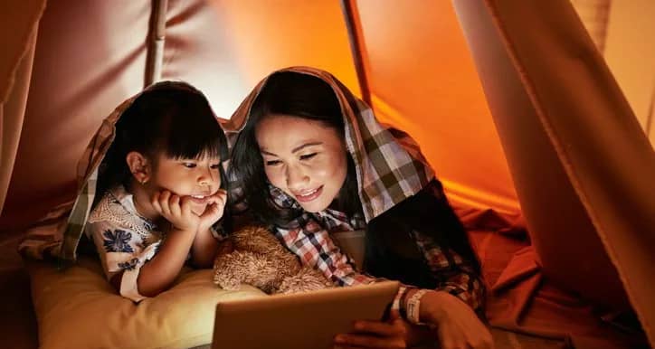 mom and young daughter watching movie on tabl.width .jpg
