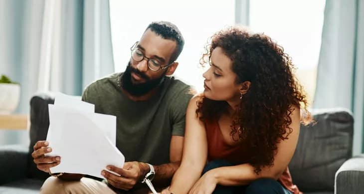 couple with bills signing papers.width .jpg