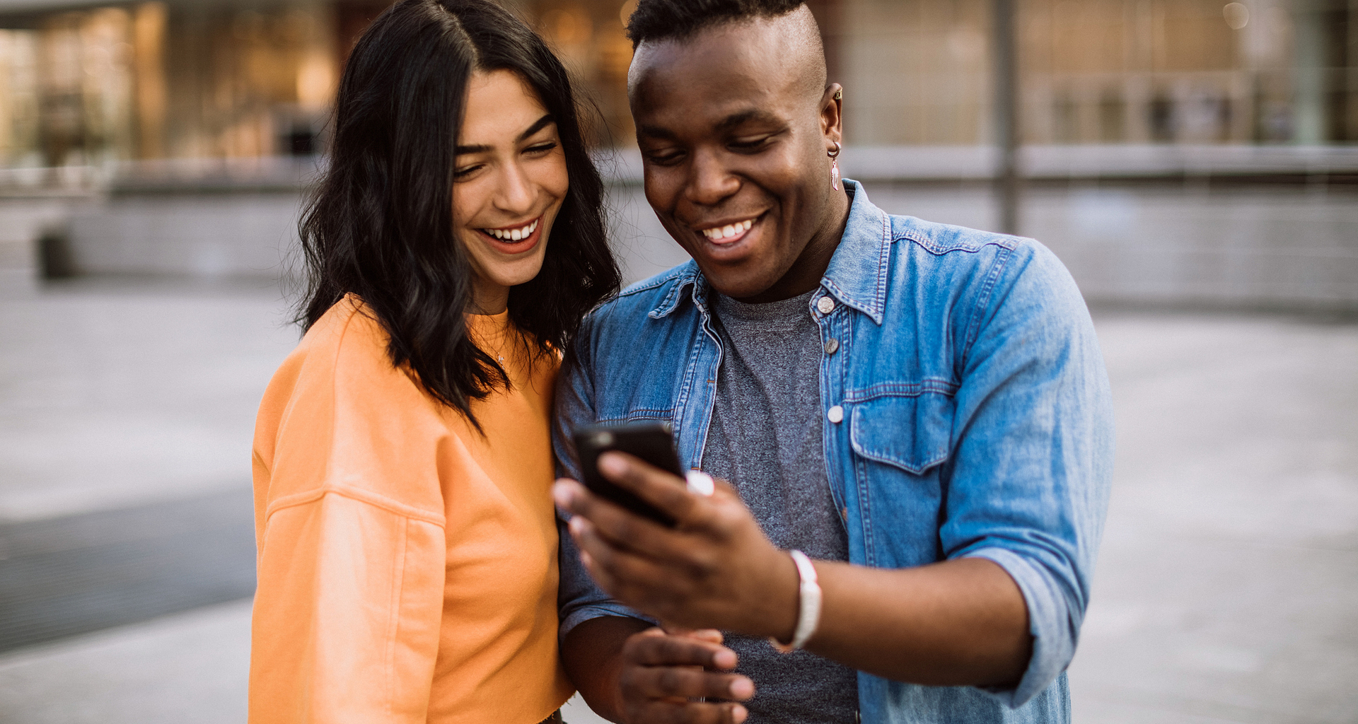 happy couple outdoors staring at phone