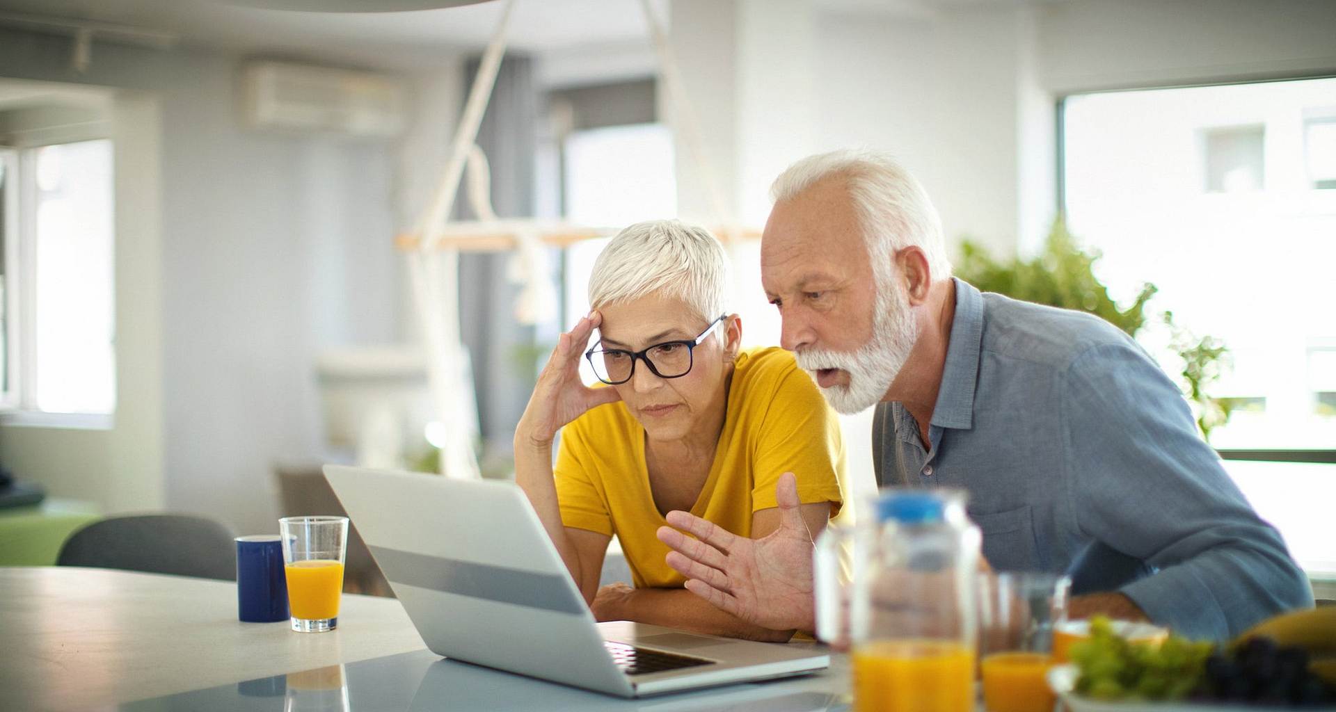 two people with stunned expressions looking at laptop