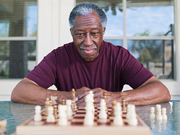 older man playing chess strategy moves winning