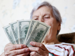 elderly woman retirement social security holding one hundred dollar bills cash getty