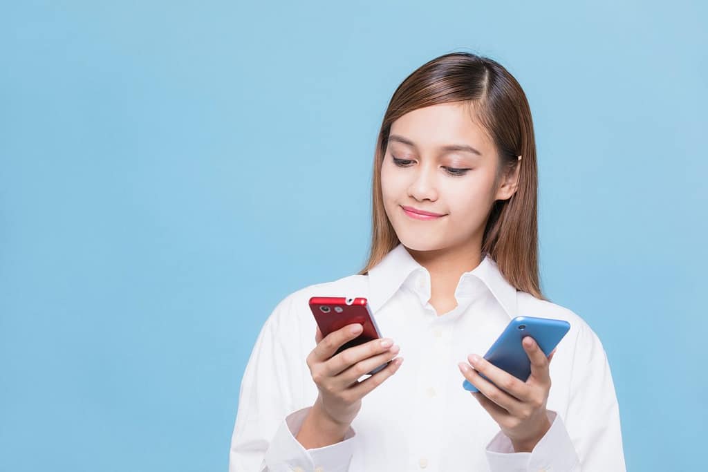 woman looking at red phone and blue phone.width .jpg