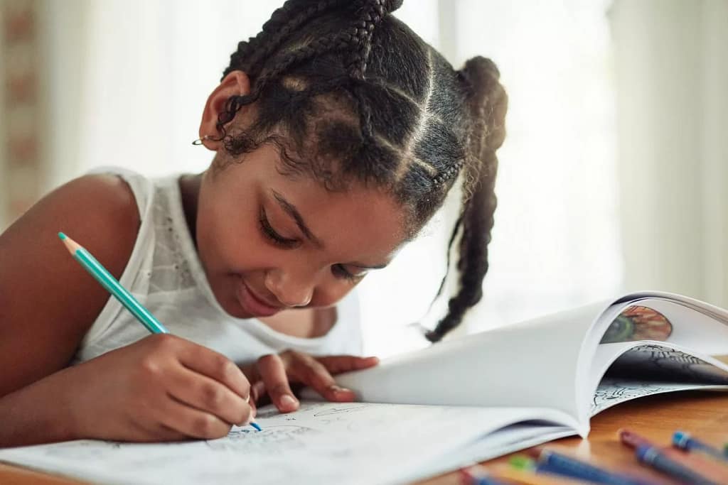 Child coloring in activity book. LGCfO.width .jpg