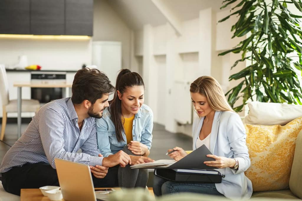 Couple signing paperwork with realtor.width .jpg