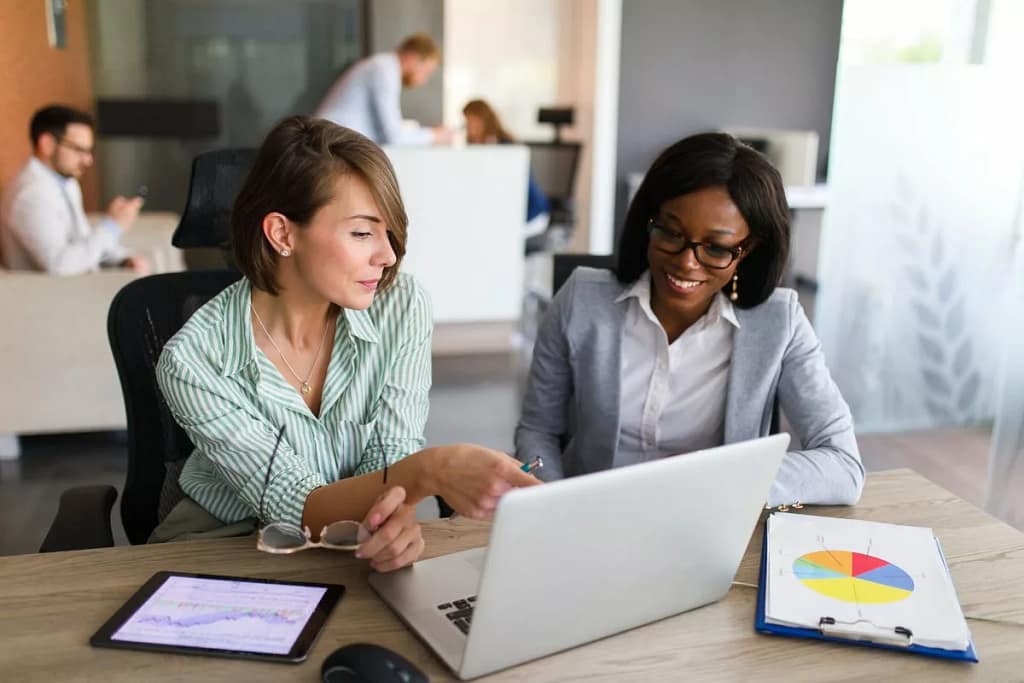 Two women looking at charts on tablet and lap.width sZnkNAm.jpg