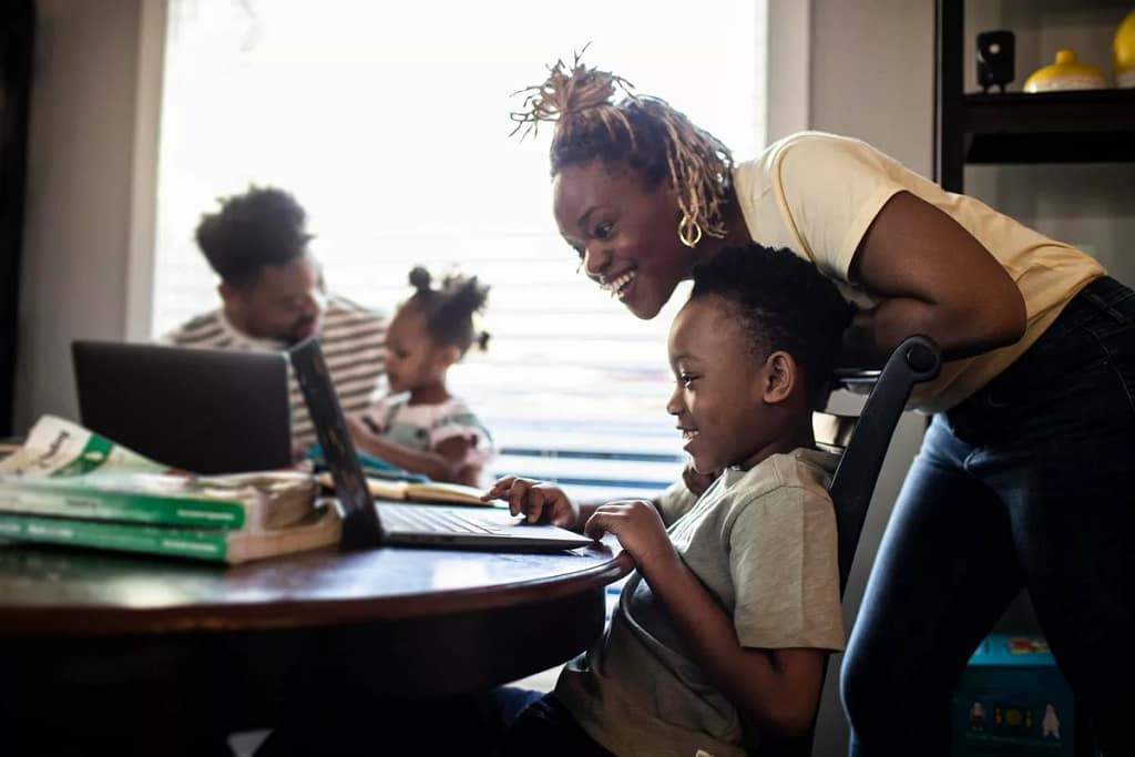 Mother helping young child with e learning on.width jYiYcn.jpg