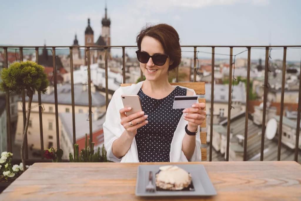 Woman holding her credit card and smiling whi.width iMSYz.jpg