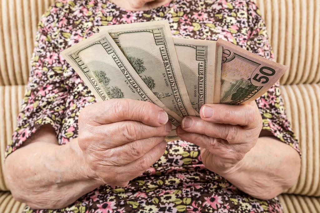 senior woman holding cash money bills social security cola retirement getty.jpg