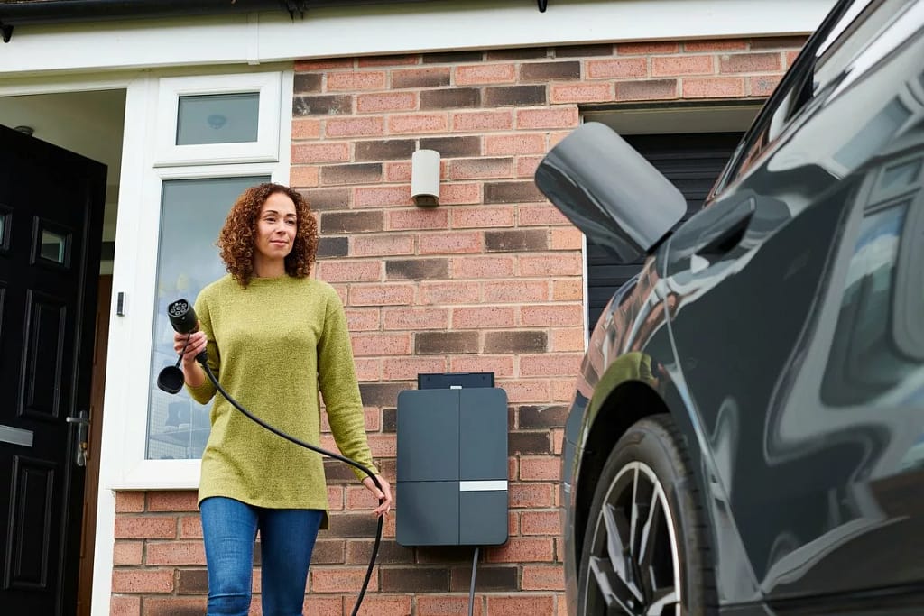Car owner charging her EV or hybrid vehicle. .width .jpg