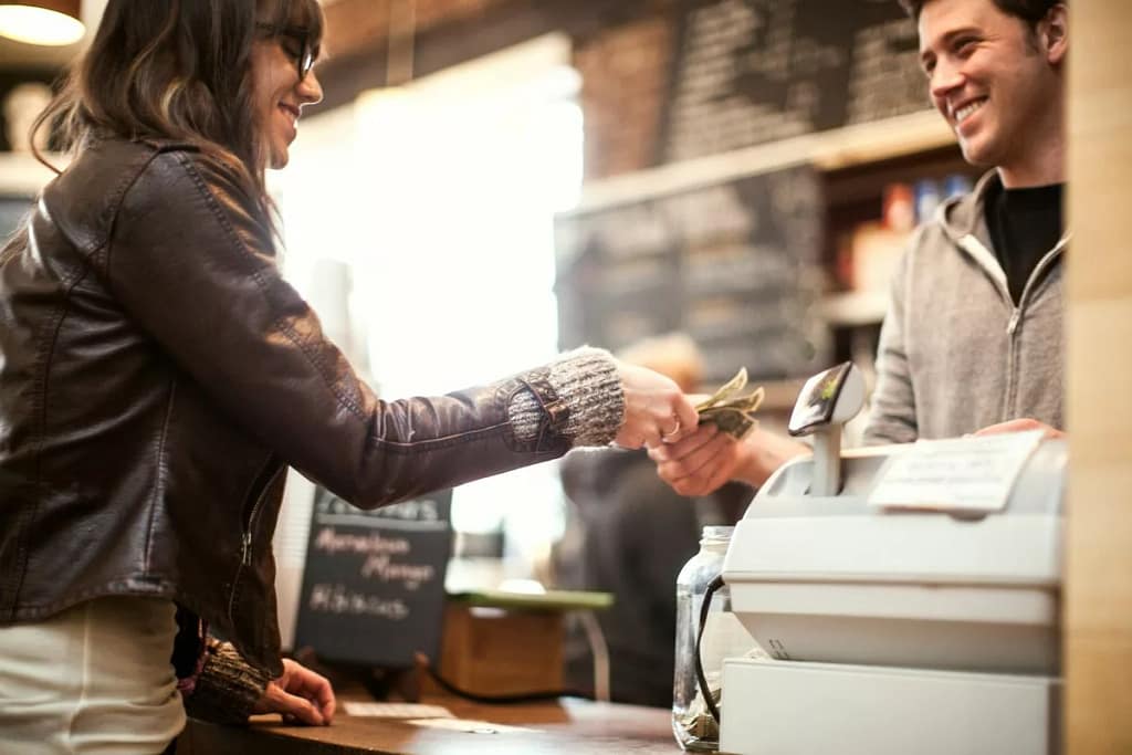 woman paying cash for coffee rXaTjn.width .jpg