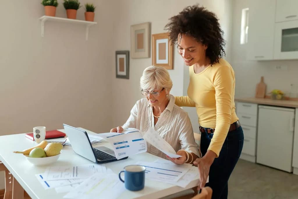 Two women look over finances in a kitchen nR.width .jpg