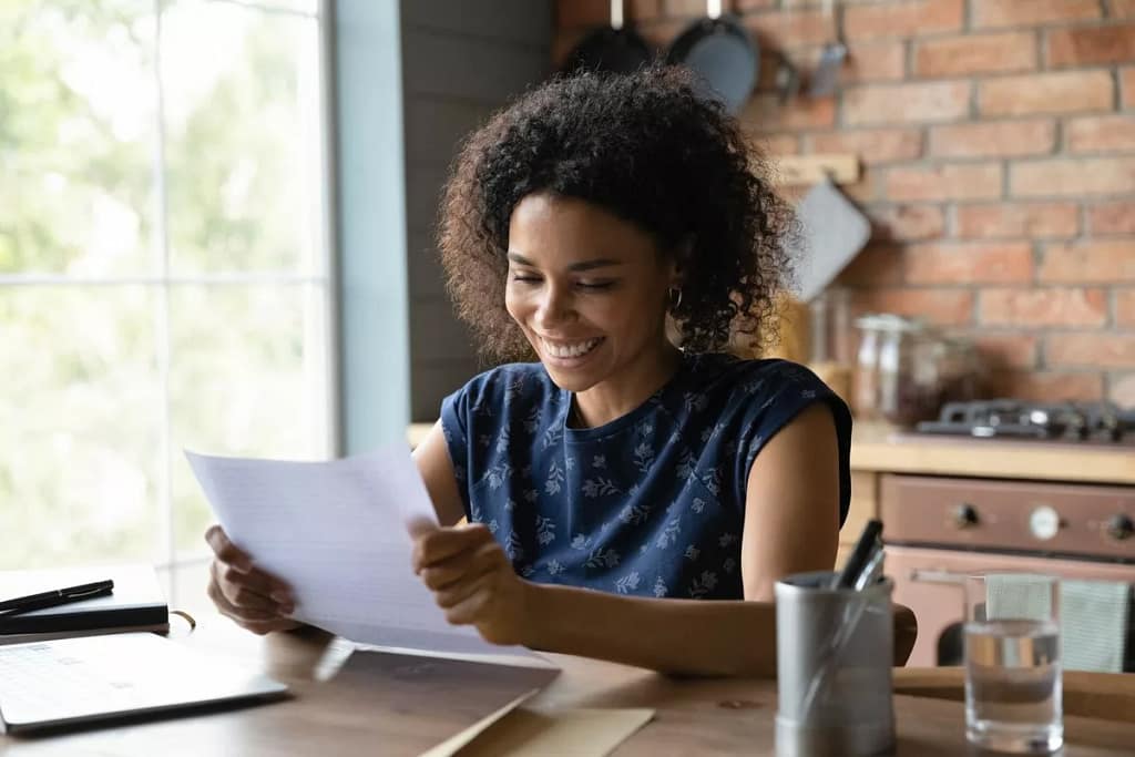 person smiling while opening mail eXwbW.width .jpg