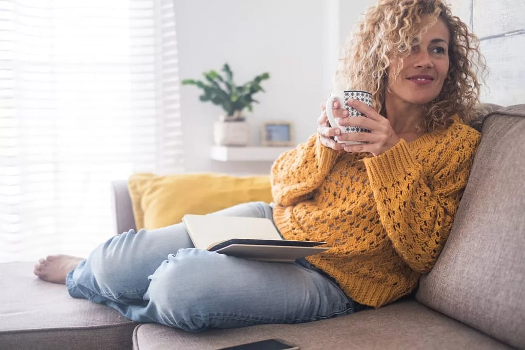 Woman drinking coffee on couch ojqxmOT.width .jpg