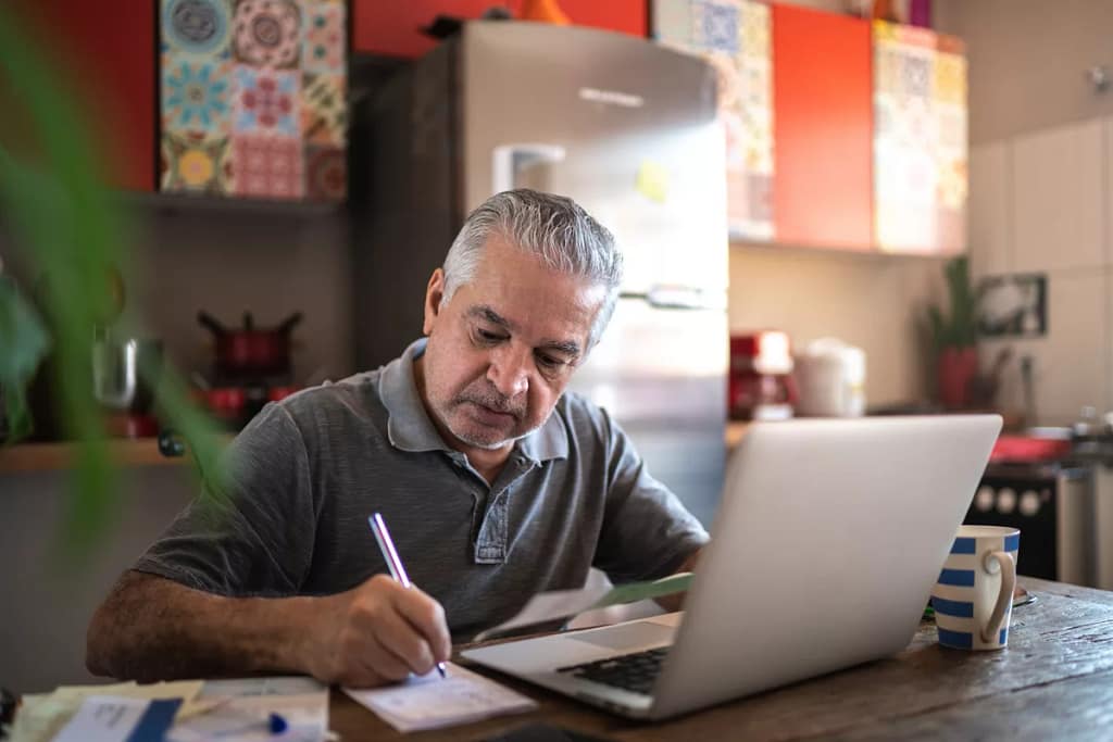 person sitting in front of laptop writing note.jpg