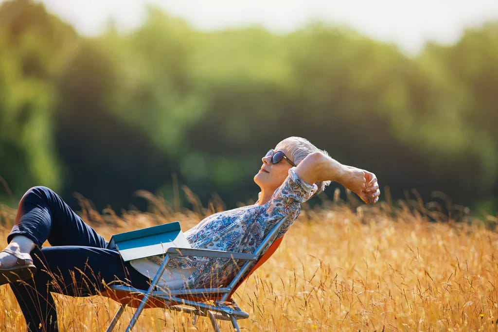 relaxed person with book on lap sitting in field.jpg