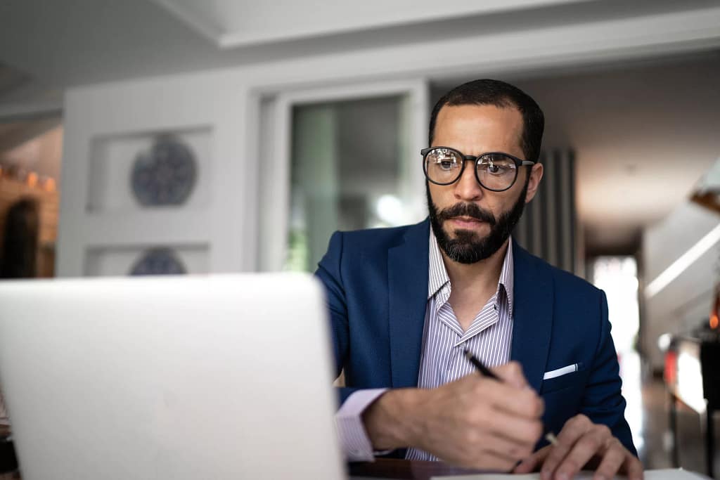 serious person staring at laptop and writing note.jpg