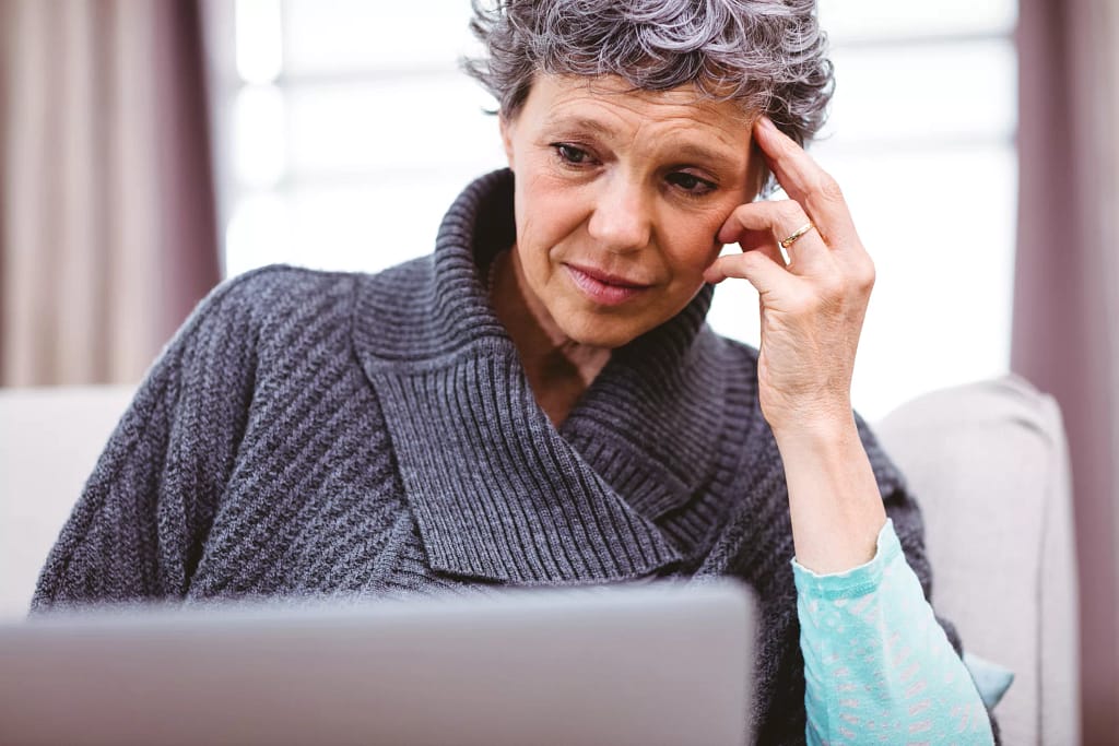 mature woman looking at laptop computer with raised eyebrows and thinking confused doubtful uncertain unsure skeptical.jpg