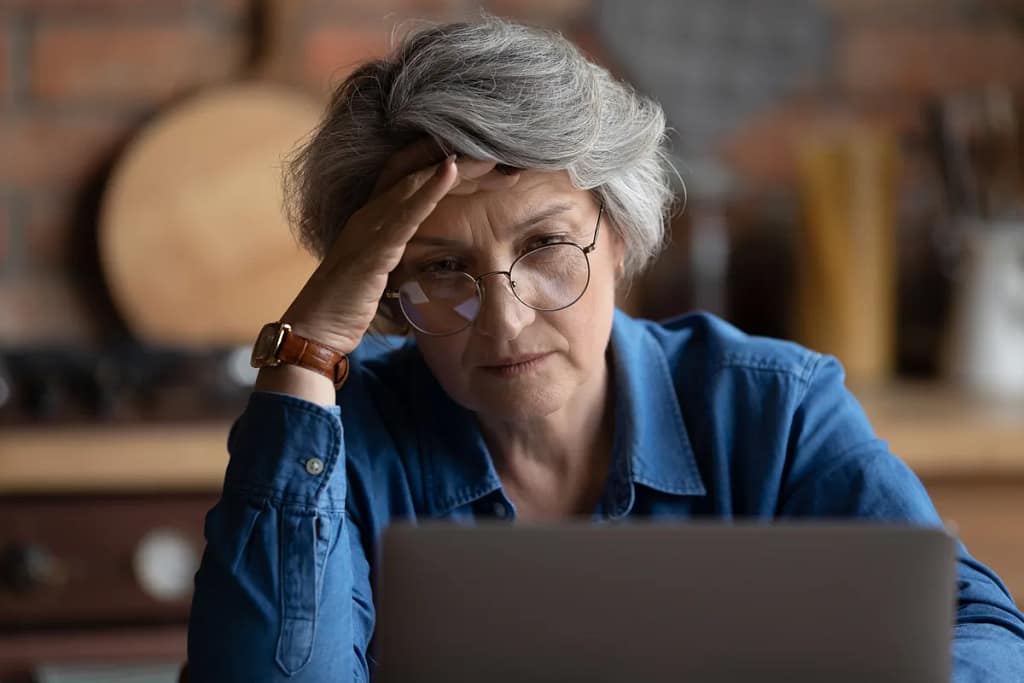 frustrated person with hand on head looking at laptop.jpg
