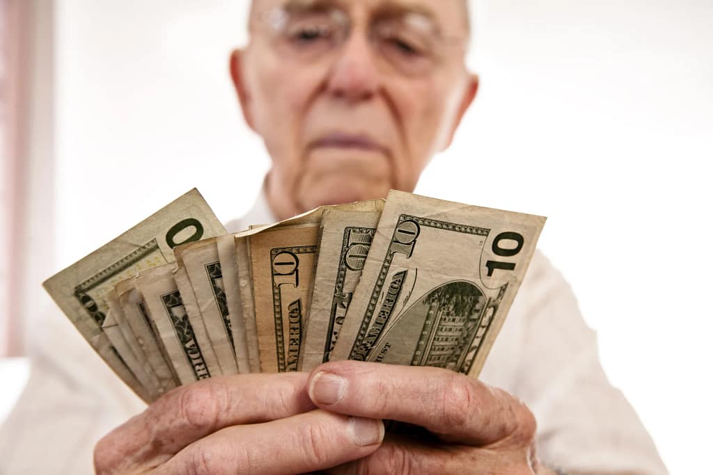 senior holding assortment cash bills social security retire getty.jpg