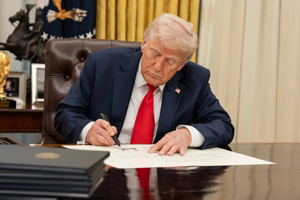white house president donald trump signing executive order at resolute desk in oval office.jpg