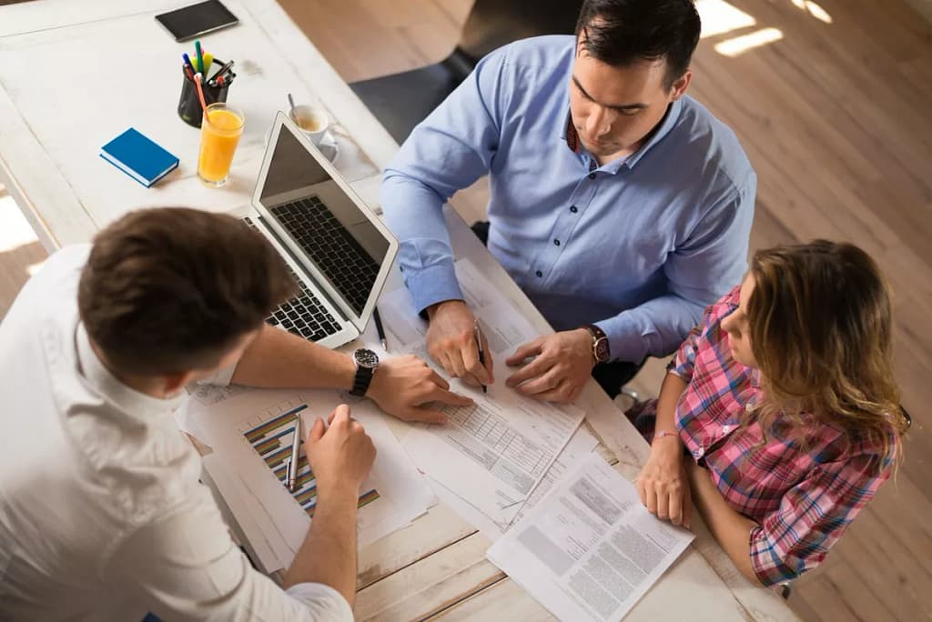 man and woman sitting across desk from man in.width qyYGV.jpg