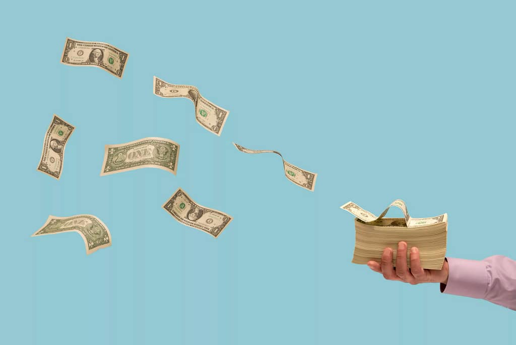 dollar bills flying off a stack of money.jpg