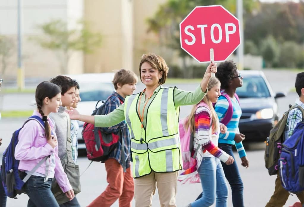 Crossing guard helping school children cross .width RDDdDn.jpg