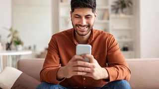 investor smiling phone at home cMrY