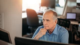 older man serious expression at computer gettyimages fzoFI