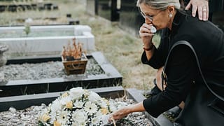 older woman at grave crying gettyimages laxCgb
