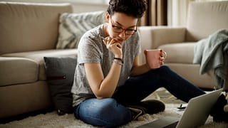 person sitting on floor looking at documents
