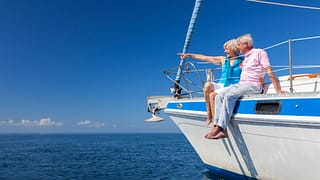 senior couple on sailboat wife pointing toward horizon czyezf