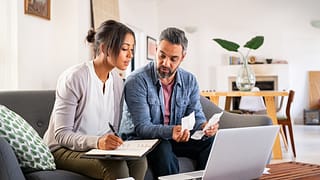 two people a laptop and their bills