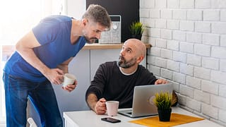 two people discussing something on laptop screen