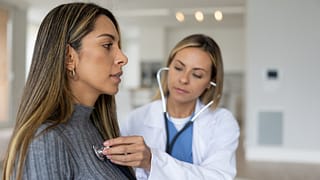 a doctor placing a stethoscope on a persons chest gettyimages