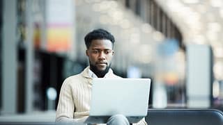 a person with a serious expression at a laptop gettyimages