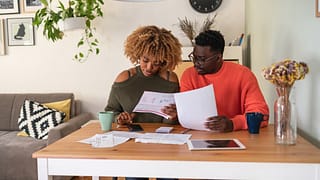 couple reviewing papers budgeting