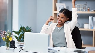 happy person celebrating at desk