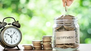 retirement savings jar full of coins and alarm clock
