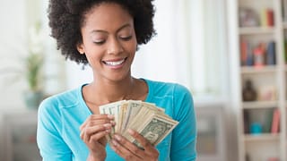 smiling person counting money