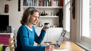 drinking coffee using laptop
