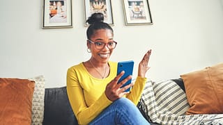 happy looking surprised while using a cellphone at home